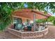 Covered patio with comfortable seating, string lights, and a decorative brick surround at 10453 W White Mountain Rd, Sun City, AZ 85351