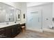 A modern bathroom featuring double sinks, quartz counters, and a spacious glass enclosed shower at 12519 W Oyer Ln, Peoria, AZ 85383