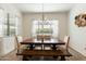 Dining room featuring a large wooden table with upholstered chairs and a bench beneath a modern chandelier at 12519 W Oyer Ln, Peoria, AZ 85383