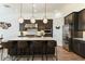 Well-appointed kitchen featuring dark cabinetry, island, and stainless steel appliances at 12519 W Oyer Ln, Peoria, AZ 85383