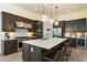 Gourmet kitchen featuring stainless steel appliances, a large island, pendant lighting and dark cabinetry at 12519 W Oyer Ln, Peoria, AZ 85383