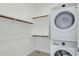 This laundry room has a stackable washer/dryer and open shelves, providing a functional and organized space at 12519 W Oyer Ln, Peoria, AZ 85383