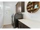 Well-organized laundry room features dark wood cabinets and a countertop, combining functionality with stylish design at 12519 W Oyer Ln, Peoria, AZ 85383