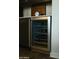 Built-in wine fridge with wine bottles, set in dark cabinetry at 12519 W Oyer Ln, Peoria, AZ 85383