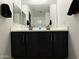 Double sink vanity in a bathroom with black cabinets and a large mirror at 13342 W Lariat Ln, Peoria, AZ 85383