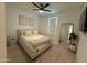 Cozy bedroom with soft carpet, a large bed, modern fan, and decorative wall art at 13342 W Lariat Ln, Peoria, AZ 85383