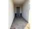 Inviting covered entryway with gray tiled floor and neutral colored door at 13342 W Lariat Ln, Peoria, AZ 85383