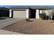 Close up view of a home's front exterior, featuring a well-maintained gravel yard and paved walkway to the entrance at 13342 W Lariat Ln, Peoria, AZ 85383