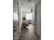 A hallway leading to a home office, complete with tile flooring, neutral walls, and a ceiling fan at 13342 W Lariat Ln, Peoria, AZ 85383