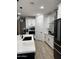 Well-lit modern kitchen featuring white cabinets, black appliances, and an island with pendant lighting at 13342 W Lariat Ln, Peoria, AZ 85383