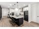 Bright kitchen with an island featuring barstool seating, a black refrigerator, and stainless steel range hood at 13342 W Lariat Ln, Peoria, AZ 85383