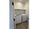 Functional laundry room is equipped with a washer, dryer, and convenient shelving at 13342 W Lariat Ln, Peoria, AZ 85383
