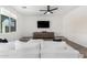 Relaxing living room featuring a plush white sofa, wall-mounted TV, and pet beds at 13342 W Lariat Ln, Peoria, AZ 85383