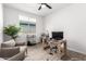 The home office features wood-look tile, bright window, ceiling fan, and stylish furniture at 13342 W Lariat Ln, Peoria, AZ 85383