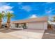 Charming single-story home featuring a two-car garage, desert landscaping, and beautiful palm trees at 13747 W Tartan Dr, Sun City West, AZ 85375