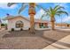 Charming single-story home featuring a two-car garage, desert landscaping, and beautiful palm trees at 13747 W Tartan Dr, Sun City West, AZ 85375