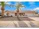 Charming single-story home featuring a two-car garage, desert landscaping, and beautiful palm trees at 13747 W Tartan Dr, Sun City West, AZ 85375