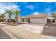 Charming single-story home featuring a two-car garage, desert landscaping, and beautiful palm trees at 13747 W Tartan Dr, Sun City West, AZ 85375