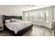 Serene main bedroom with a large window, hardwood floors, and a tufted headboard at 13747 W Tartan Dr, Sun City West, AZ 85375