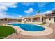 Sparkling blue pool with stone surround, lush artificial grass, and desert landscaping at 13747 W Tartan Dr, Sun City West, AZ 85375