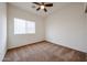 Bedroom with neutral carpet, a window with blinds, and a ceiling fan; freshly painted and move in ready at 15222 N 138Th Dr, Surprise, AZ 85379