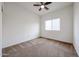 Bedroom with neutral carpet, a window with blinds, and a ceiling fan; freshly painted and move in ready at 15222 N 138Th Dr, Surprise, AZ 85379