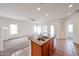 Sunlit kitchen with a central island, stainless steel sink, ample countertop space, and open access to the living area at 15222 N 138Th Dr, Surprise, AZ 85379