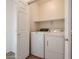 Laundry room featuring a washer and dryer with overhead shelf and white paint; neutral color and spacious at 15222 N 138Th Dr, Surprise, AZ 85379