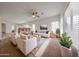 Bright living room with neutral walls, modern furniture, ceiling fan, and large windows providing lots of natural light at 15222 N 138Th Dr, Surprise, AZ 85379