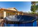 Backyard view featuring a covered swimming pool, spacious patio and mature trees, perfect for outdoor entertaining at 15558 N 136Th Ln, Surprise, AZ 85374