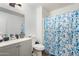 Clean bathroom featuring a vanity, mirror, and shower with a blue floral curtain at 15558 N 136Th Ln, Surprise, AZ 85374