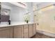 Bathroom featuring a glass shower enclosure and light wood cabinets at 15558 N 136Th Ln, Surprise, AZ 85374