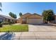 Charming home with a manicured lawn, mature trees, and a two-car garage in a quiet neighborhood at 15558 N 136Th Ln, Surprise, AZ 85374