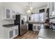 Charming kitchen with white and grey cabinets, stainless steel appliances, and wood-look floors, offering a practical cooking space at 15558 N 136Th Ln, Surprise, AZ 85374