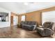 Relaxing living room with wood-look floors and comfortable seating, illuminated by natural light from the nearby windows at 15558 N 136Th Ln, Surprise, AZ 85374