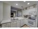 Bright kitchen features white cabinets, stainless sink, and a pass-through to the living room at 16118 W Vista North Dr, Sun City West, AZ 85375