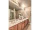 Bathroom featuring a double vanity, large mirror, and glass shower with neutral stone-style surround and white countertops at 16402 N 48Th Way, Scottsdale, AZ 85254