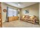 Cozy living room with floral sofa, decorative cabinet, window with curtains, and a ceiling fan at 16402 N 48Th Way, Scottsdale, AZ 85254