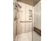 Contemporary shower with a built-in seat, travertine-style tile surround, shelving, and glass enclosure at 16402 N 48Th Way, Scottsdale, AZ 85254