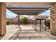 Backyard featuring a large pergola, travertine pavers, mature landscaping, and dog run at 16813 W Hammond St, Goodyear, AZ 85338