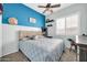 This bedroom has a ceiling fan, a large window with plantation shutters, and fun wall decor at 16813 W Hammond St, Goodyear, AZ 85338