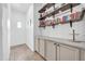 A hallway features storage cabinets, floating shelves, and tasteful decorative details at 16813 W Hammond St, Goodyear, AZ 85338