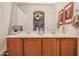 Bathroom featuring a double sink vanity with wood cabinets and a large mirror over the countertop at 1722 N 77Th Gln, Phoenix, AZ 85035