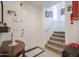 Bright entryway with tiled floors, a white front door, and carpeted stairs leading to the next level at 1722 N 77Th Gln, Phoenix, AZ 85035