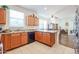 Galley kitchen with oak cabinets and black appliances and view into dining room at 1722 N 77Th Gln, Phoenix, AZ 85035