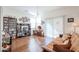 Cozy living room featuring hardwood floors, a futon, entertainment center, and lots of natural light at 1722 N 77Th Gln, Phoenix, AZ 85035