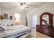 Spacious bedroom with a large bed, ceiling fan, a dresser, and a view of the ensuite bathroom at 1722 N 77Th Gln, Phoenix, AZ 85035