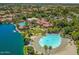 An aerial view of a community with lagoon, pool and clubhouse surrounded by green trees at 1737 E Marquette Dr, Gilbert, AZ 85234