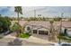 An exterior elevation view of a home with well-maintained lawn, two-car garage, and a decorative palm tree at 1737 E Marquette Dr, Gilbert, AZ 85234