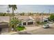 An exterior elevation view of a home with well-maintained lawn, two-car garage, and a decorative palm tree at 1737 E Marquette Dr, Gilbert, AZ 85234